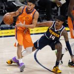 Phoenix Suns guard Devin Booker, left, is defended by Denver Nuggets guard Gary Harris during the second half of an NBA basketball game Friday, Jan. 1, 2021, in Denver. (AP Photo/David Zalubowski)