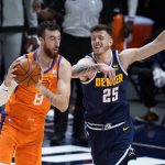 Phoenix Suns forward Frank Kaminsky, left, looks to pass the ball as Denver Nuggets center Isaiah Hartenstein defends during the second half of an NBA basketball game Friday, Jan. 1, 2021, in Denver. The Suns won 106-103. (AP Photo/David Zalubowski)