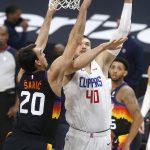 Los Angeles Clippers center Ivica Zubac (40) shoots over the defense of Phoenix Suns forward Dario Saric (20) during the first half of an NBA basketball game Sunday, Jan. 3, 2021, in Phoenix. (AP Photo/Ralph Freso)