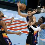 Phoenix Suns guard Devin Booker, middle, and forward Mikal Bridges (25) vie for a rebound with Houston Rockets guard Victor Oladipo (7) during the second half of an NBA basketball game Wednesday, Jan. 20, 2021, in Houston. (AP Photo/Michael Wyke)
