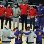 Members of the Phoenix Suns and the Toronto Raptors form a circle during the American national anthem prior to an NBA basketball game Wednesday, Jan. 6, 2021, in Phoenix. (AP Photo/Ross D. Franklin)