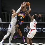 Phoenix Suns guard Cameron Payne (15) drives to the basket between the defense of Los Angeles Clippers guards Luke Kennard (5) and Lou Williams (23) during the first half of an NBA basketball game Sunday, Jan. 3, 2021, in Phoenix. (AP Photo/Ralph Freso)