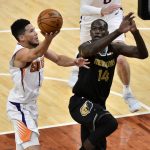 Phoenix Suns guard Devin Booker (1) shoots against Memphis Grizzlies center Gorgui Dieng (14) in the first half of an NBA basketball game Monday, Jan. 18, 2021, in Memphis, Tenn. (AP Photo/Brandon Dill)