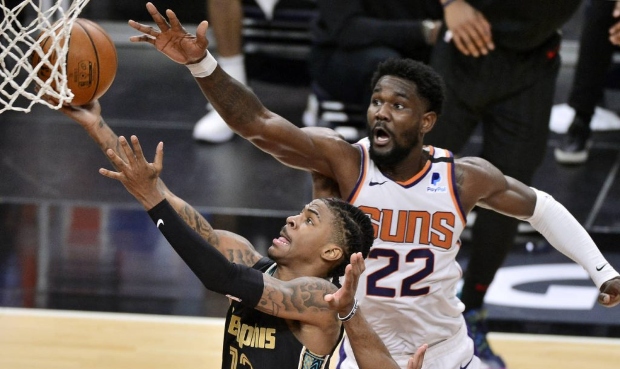 Memphis Grizzlies guard Tim Frazier (12) shoots ahead of Phoenix Suns center Deandre Ayton (22) in ...