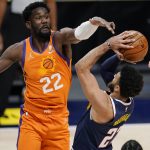 Phoenix Suns center Deandre Ayton, left, goes up to block a shot by Denver Nuggets guard Jamal Murray during the second half of an NBA basketball game Friday, Jan. 1, 2021, in Denver. (AP Photo/David Zalubowski)