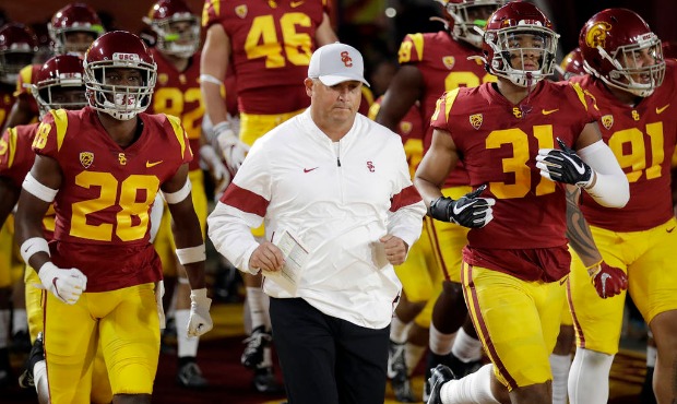 Southern California coach Clay Helton runs onto the field with this team for the start of an NCAA c...
