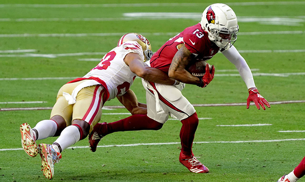 Arizona Cardinals wide receiver Christian Kirk (13) is hit by San Francisco 49ers cornerback Ahkell...