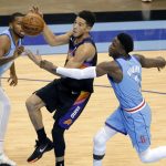 Phoenix Suns guard Devin Booker, middle, loses the ball on a shot attempt as he is fouled by Houston Rockets guard Victor Oladipo (7), while guard Sterling Brown, left, watches during the second half of an NBA basketball game Wednesday, Jan. 20, 2021, in Houston. (AP Photo/Michael Wyke)