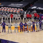 Members of the Phoenix Suns and the Toronto Raptors form a circle during the American national anthem prior to a basketball game Wednesday, Jan. 6, 2021, in Phoenix. (AP Photo/Ross D. Franklin)