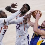Indiana Pacers' Domantas Sabonis (11) grabs a rebound against Phoenix Suns' Jae Crowder (99) and Deandre Ayton (22) during the second half of an NBA basketball game, Saturday, Jan. 9, 2021, in Indianapolis. (AP Photo/Darron Cummings)