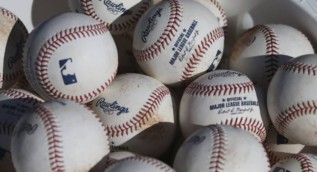 In this Feb. 14, 2020, file photo, baseballs occupy a bucket after use during fielding practice dur...
