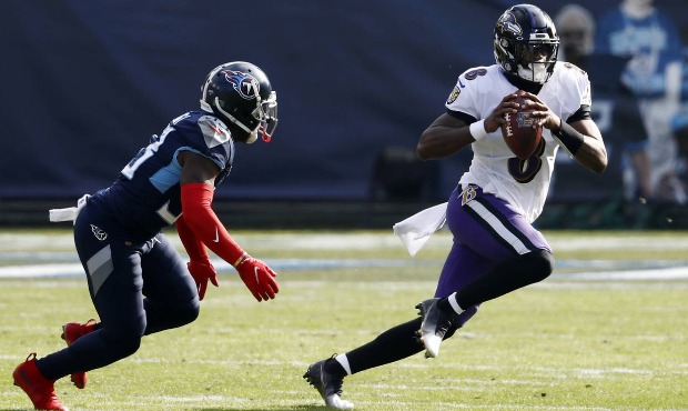 Baltimore Ravens quarterback Lamar Jackson (8) scrambles away from Tennessee Titans cornerback Desm...