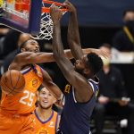 Phoenix Suns forward Mikal Bridges, left, fouls Denver Nuggets forward JaMychal Green on a dunk during the second half of an NBA basketball game Friday, Jan. 1, 2021, in Denver. (AP Photo/David Zalubowski)