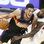 Phoenix Suns guard Devin Booker (1) drives as Los Angeles Clippers guard Patrick Beverley defends during the second half of an NBA basketball game Sunday, Jan. 3, 2021, in Phoenix. (AP Photo/Ralph Freso)