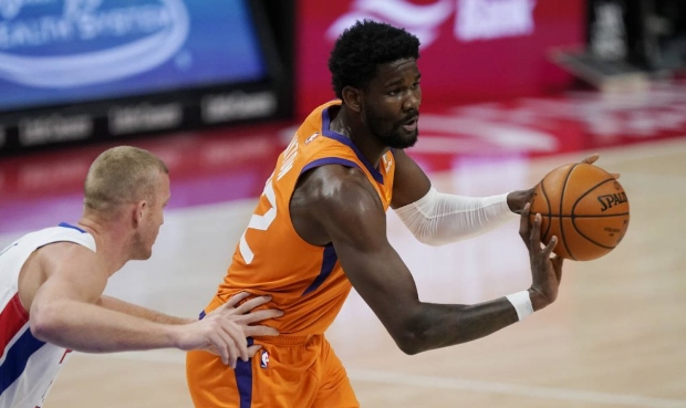 Phoenix Suns center Deandre Ayton, right, passes as Detroit Pistons center Mason Plumlee defends du...