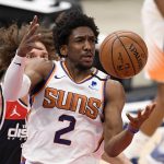 Phoenix Suns guard Langston Galloway (2) reaches for the ball in front of Washington Wizards center Robin Lopez, back, during the first half of an NBA basketball game, Monday, Jan. 11, 2021, in Washington. (AP Photo/Nick Wass)