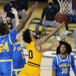 Arizona State guard Holland Woods (0) drives between UCLA forward Jalen Hill (24), guard Jake Kyman (13) and guard Tyger Campbell (10) during the first half of an NCAA college basketball game Thursday, Jan. 7, 2021, in Tempe, Ariz. (AP Photo/Ross D. Franklin)