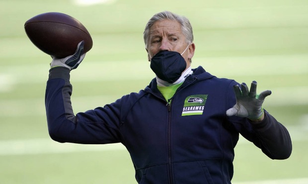 Seattle Seahawks head coach Pete Carroll tosses a football before an NFL wild-card playoff football...