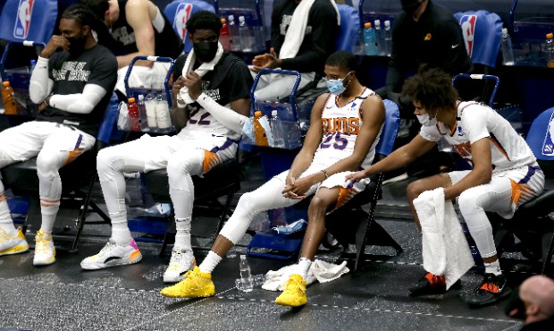 Phoenix Suns players sit courtside in the midst of a 123-101 defeat at the hands of the New Orleans...