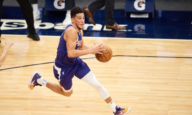 Devin Booker #1 of the Phoenix Suns drives to the basket against the Minnesota Timberwolves during ...