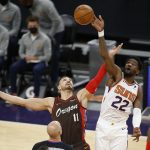 Phoenix Suns' Deandre Ayton wins the tip-off against the Portland Trail Blazers' Enes Kanter during the first half of an NBA basketball game Monday, Feb. 22, 2021, in Phoenix. (AP Photo/Darryl Webb)