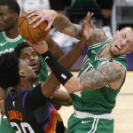 Boston Celtics forward Daniel Theis, right, is fouled by Phoenix Suns center Damian Jones, left, as he grabs a rebound during the first half of an NBA basketball game, Sunday, Feb. 7, 2021, in Phoenix. (AP Photo/Ralph Freso)