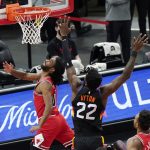 Chicago Bulls guard Coby White, left, shoots against Phoenix Suns center Deandre Ayton during the first half of an NBA basketball game in Chicago, Friday, Feb. 26, 2021. (AP Photo/Nam Y. Huh)
