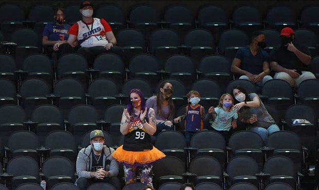 A Phoenix Suns fan stands and applauds during he second half of an NBA basketball game between the ...