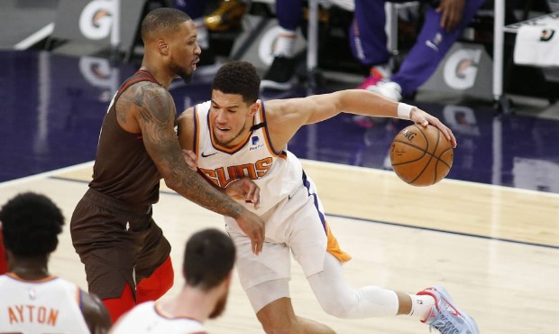 Phoenix Suns' Devin Booker muscles his way towards the basket against Portland Trail Blazers' Damie...