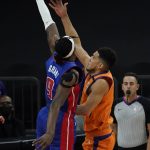 Detroit Pistons forward Jerami Grant (9) blocks the shot of Phoenix Suns guard Devin Booker, front right, during the first half of an NBA basketball game, Friday, Feb. 5, 2021, in Phoenix. (AP Photo/Matt York)