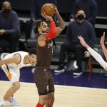 Portland Trail Blazers' Gary Trent Jr. puts up a shot against the Phoenix Suns' Frank Kaminsky III as Devin Booker looks on during the first half of an NBA basketball game Monday, Feb. 22, 2021, in Phoenix. (AP Photo/Darryl Webb)