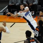 Orlando Magic guard Michael Carter-Williams (7) makes an off-balance pass in front of Phoenix Suns' Cameron Payne, Jae Crowder (99), and Deandre Ayton (22) during the second half of an NBA basketball game Sunday, Feb. 14, 2021, in Phoenix. (AP Photo/Rick Scuteri)