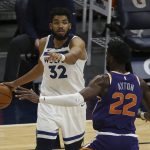 Minnesota Timberwolves's Karl-Anthony Towns (32) controls the ball against Phoenix Suns' Deandre Ayton (22) in the second half of an NBA basketball game Sunday, Feb. 28, 2021, in Minneapolis. (AP Photo/Stacy Bengs)
