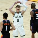 Milwaukee Bucks guard Donte DiVincenzo (0) reacts at the end of an NBA basketball game, as Phoenix Suns guard Devin Booker (1) and guard Chris Paul (3) walk to the bench Wednesday, Feb. 10, 2021, in Phoenix. The Suns won 125-124. (AP Photo/Matt York)