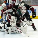 Arizona Coyotes goaltender Adin Hill (31) makes a save on a shot as Coyotes center Christian Dvorak (18) defends against Colorado Avalanche right wing Joonas Donskoi (72) during the second period of an NHL hockey game Friday, Feb. 26, 2021, in Glendale, Ariz. (AP Photo/Ross D. Franklin)