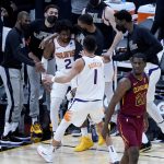 Phoenix Suns guard Langston Galloway (2) celebrates with teammates and guard Devin Booker (1) after making a shot during the first half of an NBA basketball game, Monday, Feb. 8, 2021, in Phoenix. (AP Photo/Matt York)