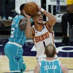 Phoenix Suns guard Devin Booker (1) drives past Charlotte Hornets guard Terry Rozier (3) during the second half of an NBA basketball game, Wednesday, Feb. 24, 2021, in Phoenix. (AP Photo/Matt York)