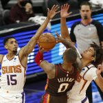 Portland Trail Blazers' Damien Lillard had nowhere to go against the defense of Phoenix Suns' Cameron Payne (15) and Cam Johnson (23) during the second half of an NBA basketball game Monday, Feb. 22, 2021, in Phoenix. (AP Photo/Darryl Webb)