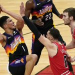 Phoenix Suns guard Devin Booker, left, drives to the basket against Chicago Bulls guard Zach LaVine, center, and forward Luke Kornet during the first half of an NBA basketball game in Chicago, Friday, Feb. 26, 2021. (AP Photo/Nam Y. Huh)