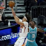 
              Phoenix Suns forward Cameron Johnson (23) shoots past Charlotte Hornets guard Terry Rozier (3) during the first half of an NBA basketball game, Wednesday, Feb. 24, 2021, in Phoenix. (AP Photo/Matt York)
            