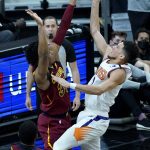 Phoenix Suns guard Devin Booker, right, shoots over Cleveland Cavaliers center Jarrett Allen during the first half of an NBA basketball game, Monday, Feb. 8, 2021, in Phoenix. (AP Photo/Matt York)