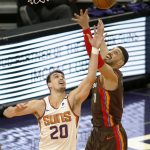 Phoenix Suns' Dario Saric, left, battles with Portland Trail Blazers' Enes Kanter, right, for a rebound during the first half of an NBA basketball game Monday, Feb. 22, 2021, in Phoenix. (AP Photo/Darryl Webb)