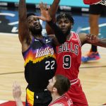 Phoenix Suns center Deandre Ayton, left, battles for a rebound against Chicago Bulls forward Patrick Williams, right, and forward Luke Kornet during the first half of an NBA basketball game in Chicago, Friday, Feb. 26, 2021. (AP Photo/Nam Y. Huh)
