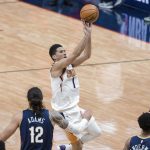 Phoenix Suns guard Devin Booker (1) shoots over New Orleans Pelicans center Steven Adams (12) and guard Nickeil Alexander-Walker (6) and guard Lonzo Ball (2) in the third quarter of an NBA basketball game in New Orleans, Wednesday, Feb. 3, 2021. (AP Photo/Derick Hingle)