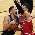 Phoenix Suns guard Devin Booker, left, drives to the basket as Chicago Bulls guard Zach LaVine guards during the first half of an NBA basketball game in Chicago, Friday, Feb. 26, 2021. (AP Photo/Nam Y. Huh)