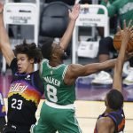 Boston Celtics guard Kemba Walker (8) drives to the basket between the defense of Phoenix Suns forward Cam Johnson (23) and Mikal Bridges, right, during the second half of an NBA basketball game, Sunday, Feb. 7, 2021, in Phoenix. (AP Photo/Ralph Freso)