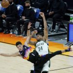 
              Phoenix Suns guard Devin Booker (1) collides with Milwaukee Bucks forward Giannis Antetokounmpo (34) while chasing the ball during the second half of an NBA basketball game Wednesday, Feb. 10, 2021, in Phoenix. (AP Photo/Matt York)
            
