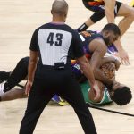 Boston Celtics forward Semi Ojeleye, bottom, and Phoenix Suns guard E'Twaun Moore, top, wrestle for control of a loose ball in front of an official during the second half of an NBA basketball game, Sunday, Feb. 7, 2021, in Phoenix. (AP Photo/Ralph Freso)