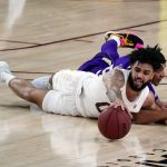 Arizona State guard Holland Woods (0) dives for the ball against Washington guard Quade Green during the first half of an NCAA college basketball game, Thursday, Feb. 25, 2021, in Tempe, Ariz. (AP Photo/Rick Scuteri)
