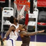Phoenix Suns' Deandre Ayton blocks the shot of Portland Trail Blazers Damian Lillard during the first half of an NBA basketball game Monday, Feb. 22, 2021, in Phoenix. (AP Photo/Darryl Webb)